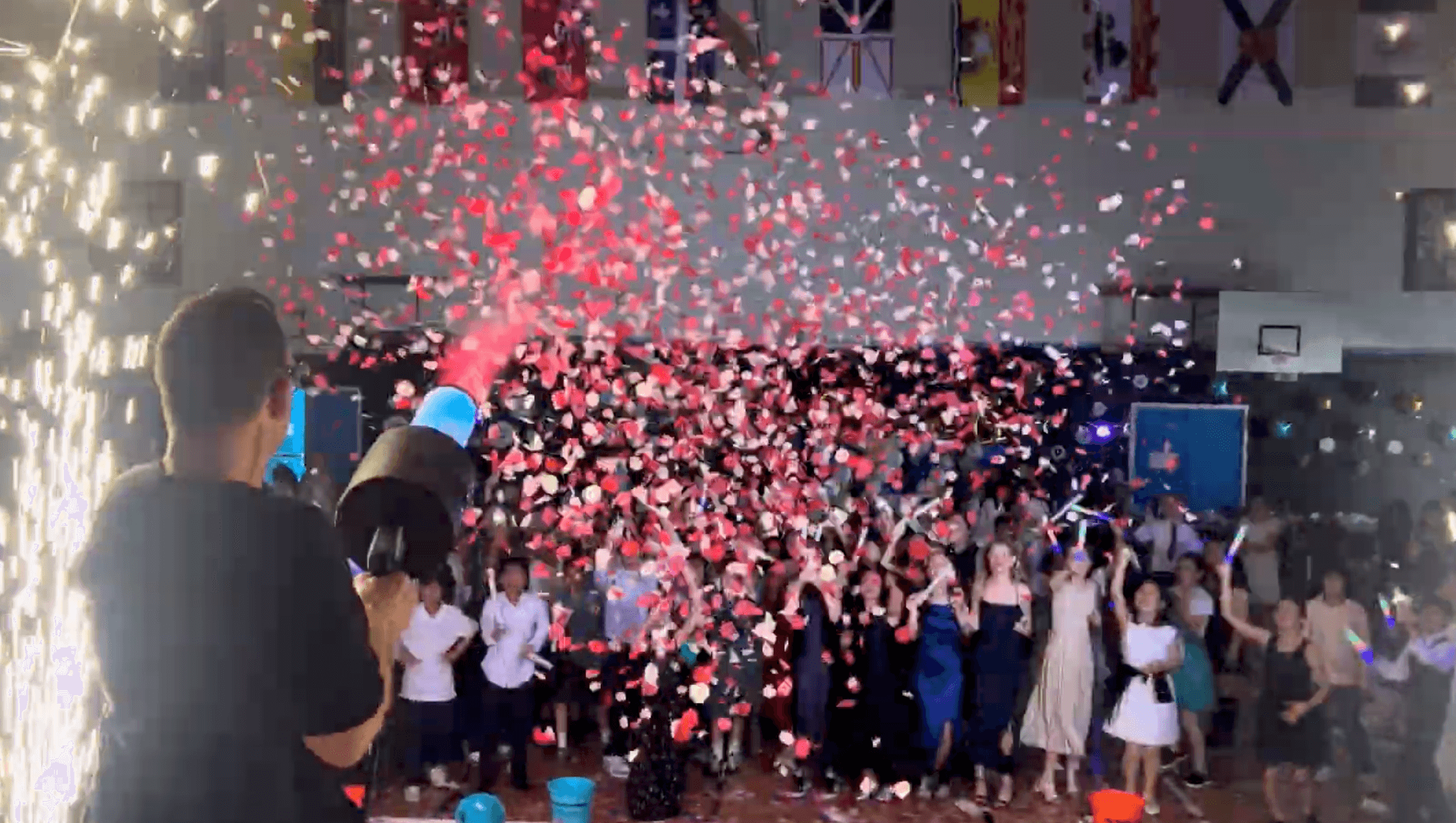 A confetti cannon firing over a packed dance floor at a Vancouver school event.