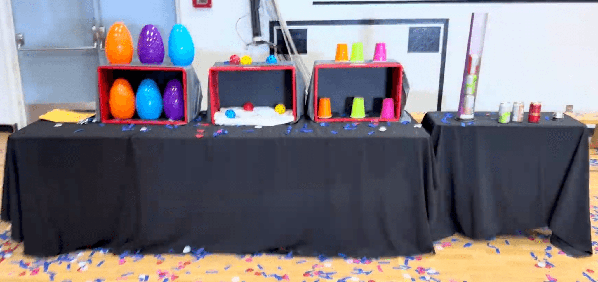 Game stations set up before a Vancouver kids party, with colour coded eggs, balls and stacking cups laid out across the tables.