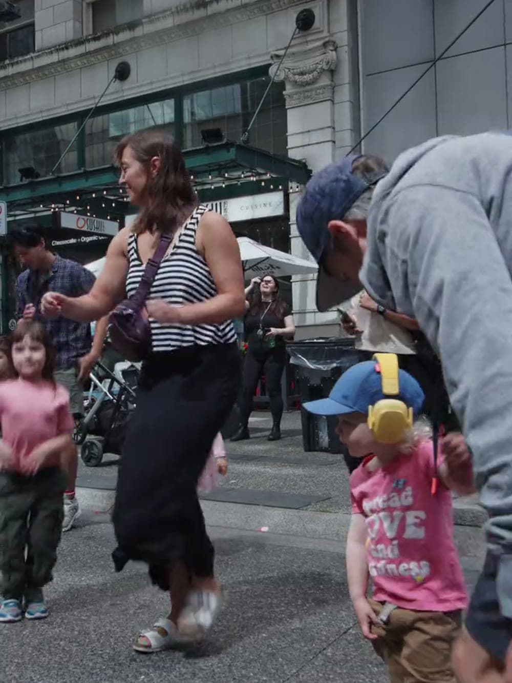 Parent and toddler dancing together at a daytime baby rave in downtown Vancouver.
