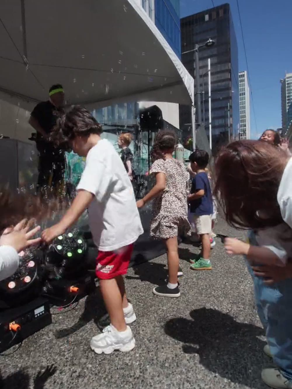 Children dancing in the street at a family baby rave in Vancouver.