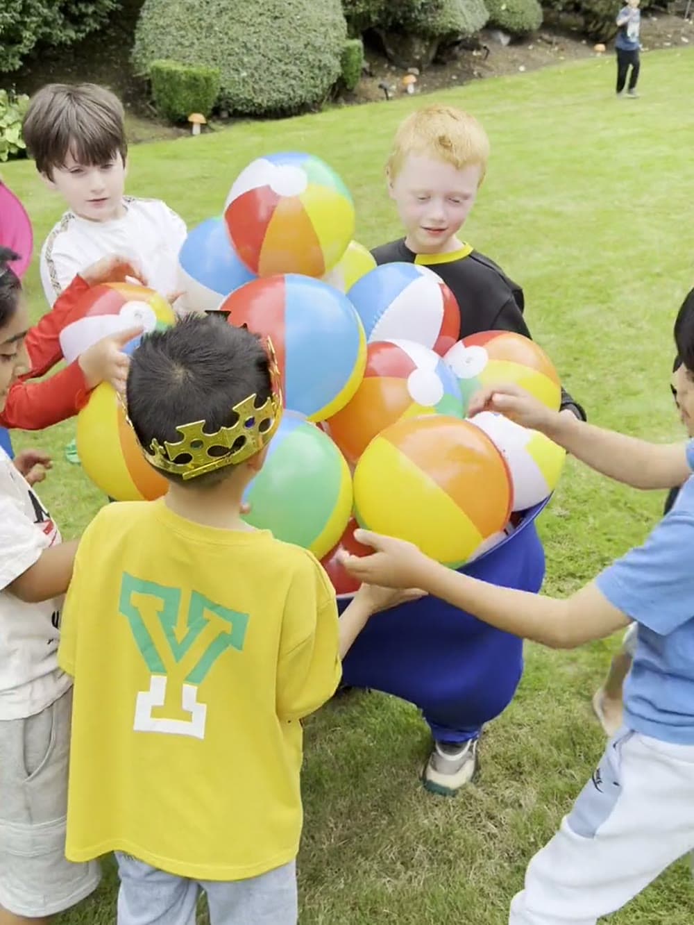 Boys crowding round a pile of beach balls during a team game at a Vancouver birthday party.