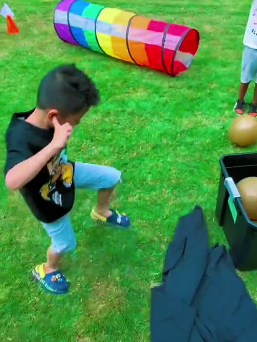 Boy running a backyard game on the grass at a Vancouver birthday party.