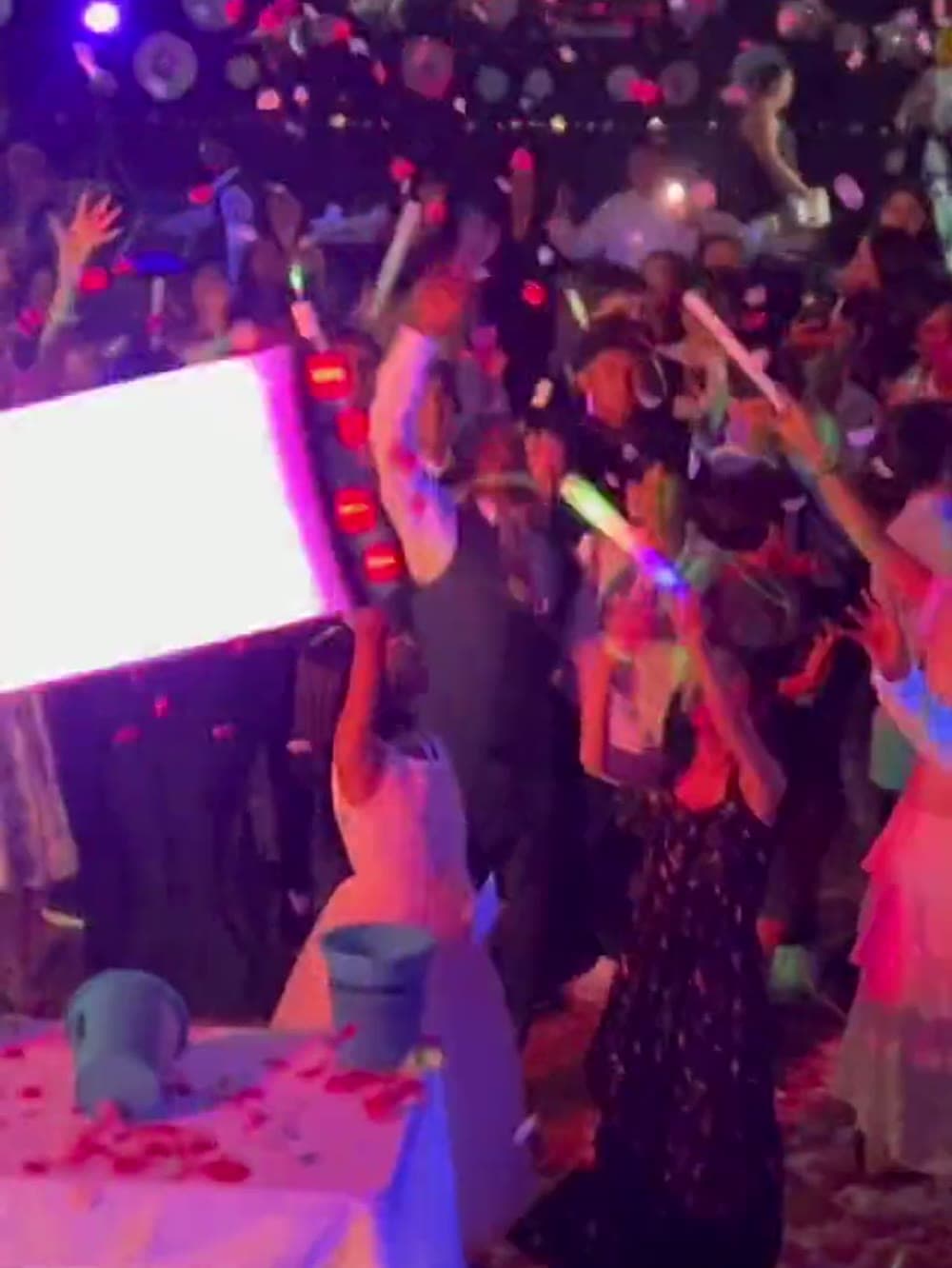 Crowd with glow sticks in the air under confetti at a Vancouver event.