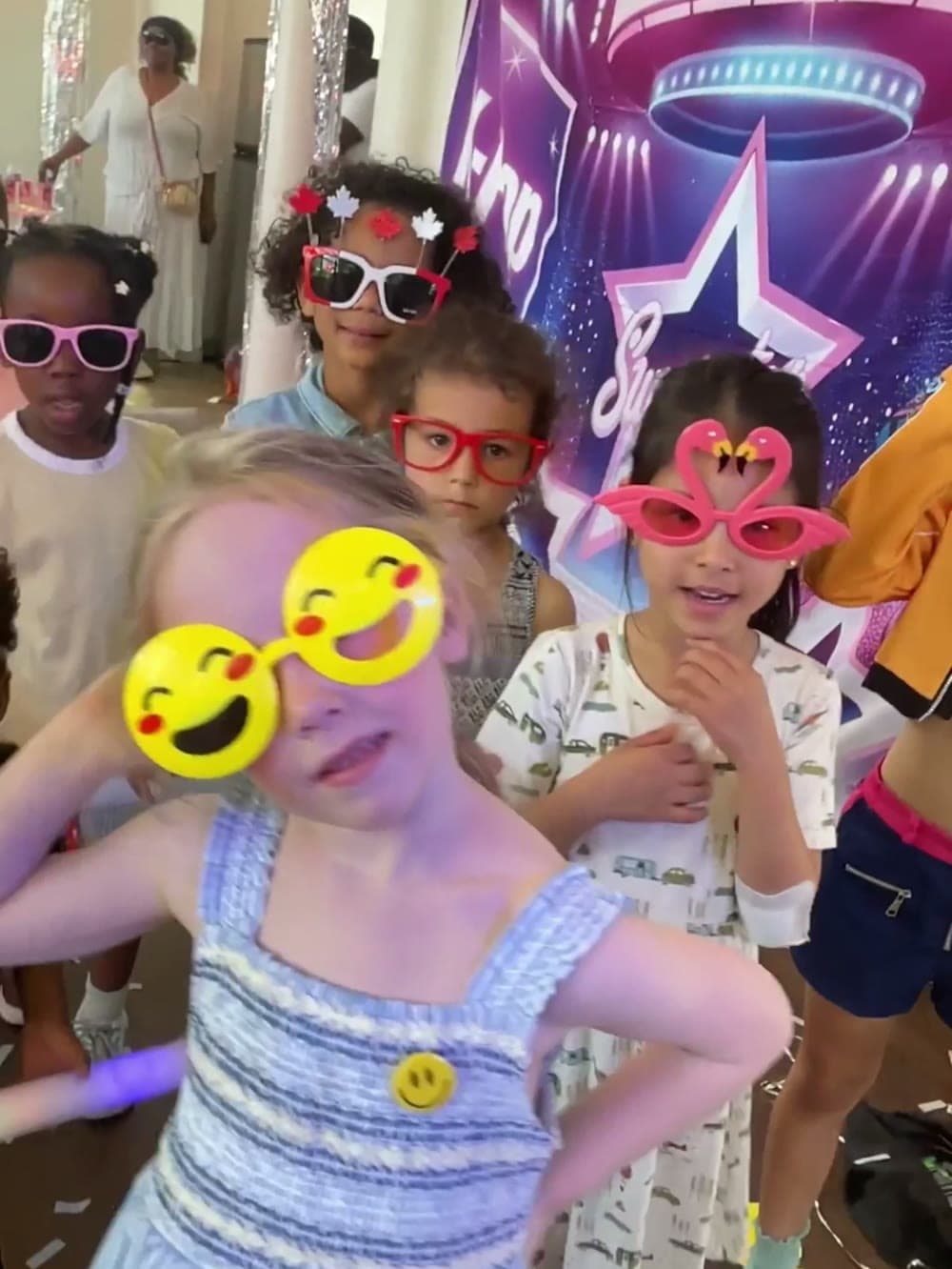 Girls in novelty sunglasses dancing together at a Vancouver birthday party.