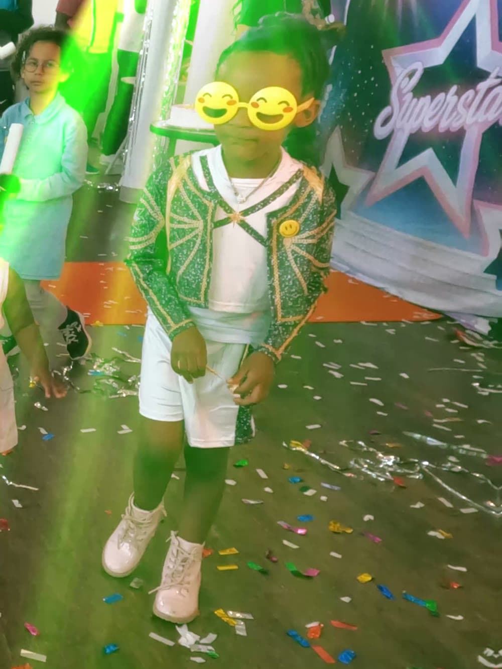 Child in emoji sunglasses walking through confetti at a Vancouver birthday party.