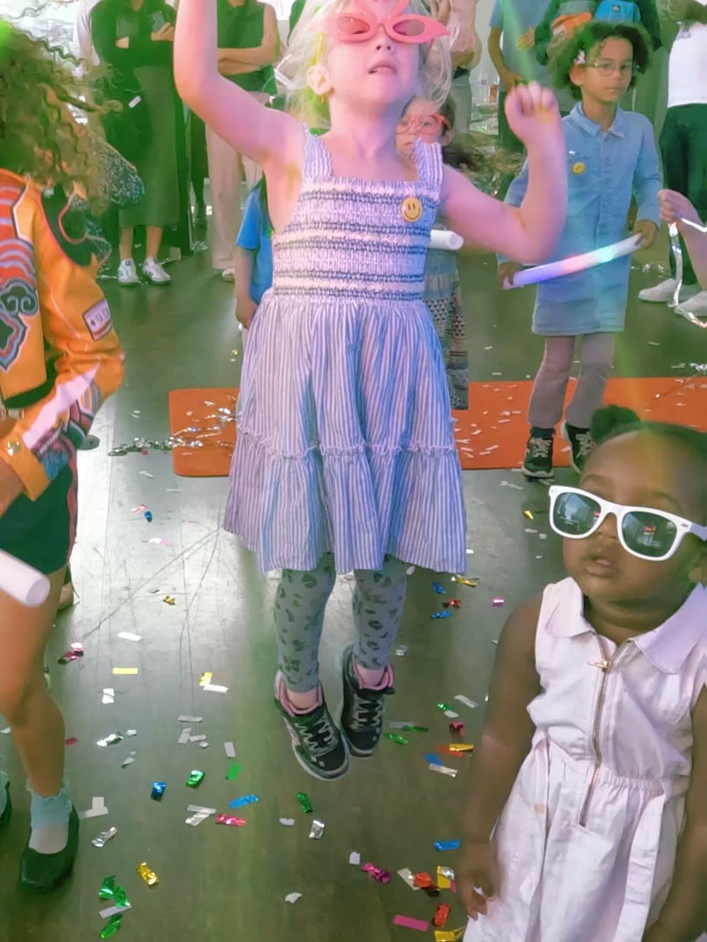Girl jumping in the air over a floor covered in confetti at a Vancouver party.