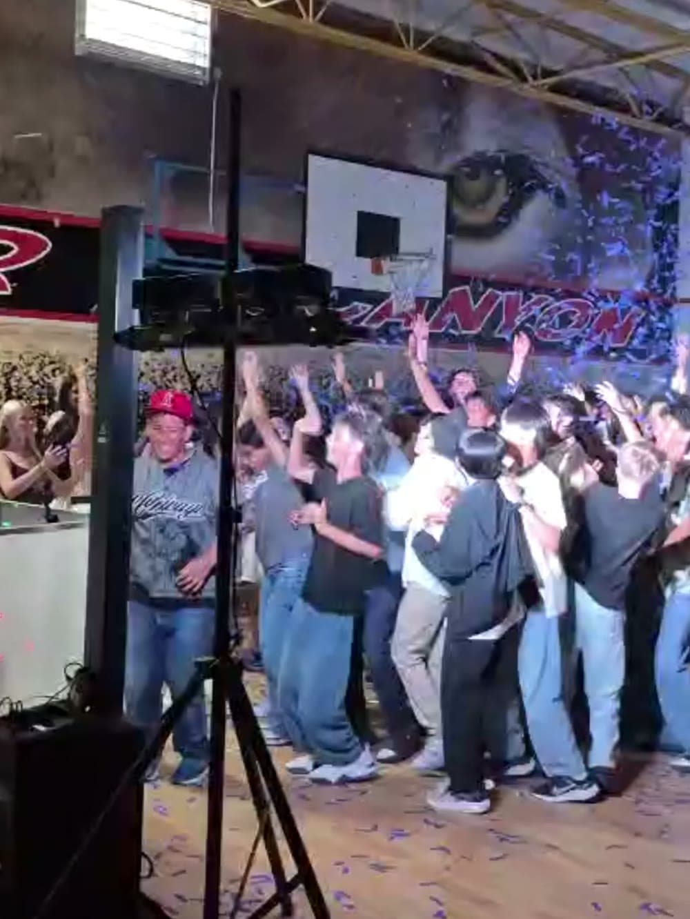 Students with hands in the air in front of the DJ booth at a Vancouver school dance.